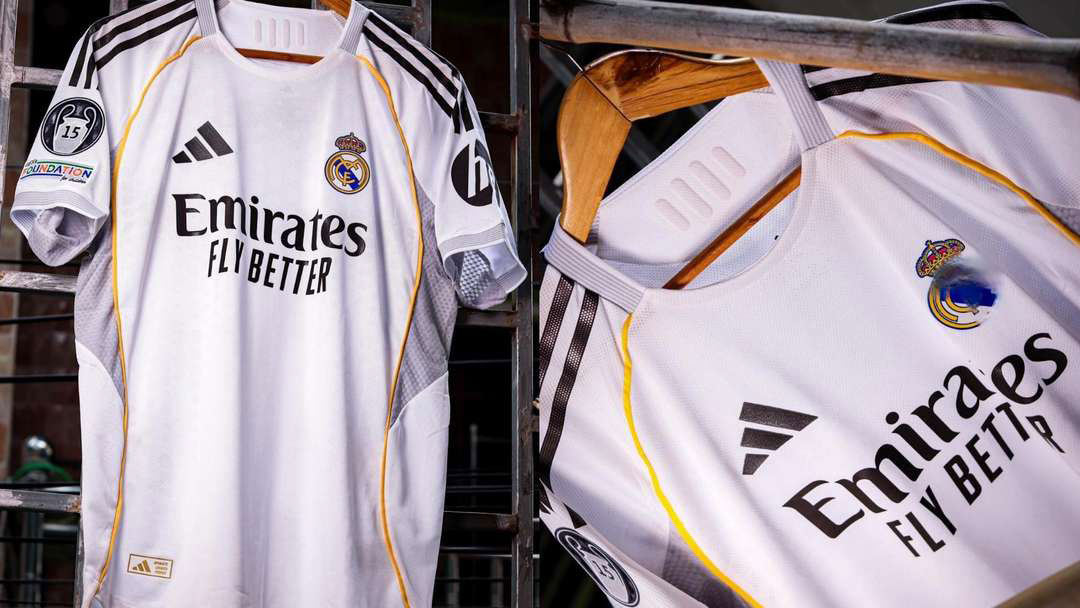 Nový domácí dres Realu Madrid pro sezónu 2025-26. Klasická bílá s moderními žlutými a šedými akcenty. Detailní pohled na logo klubu a sponzora Emirates Fly Better.